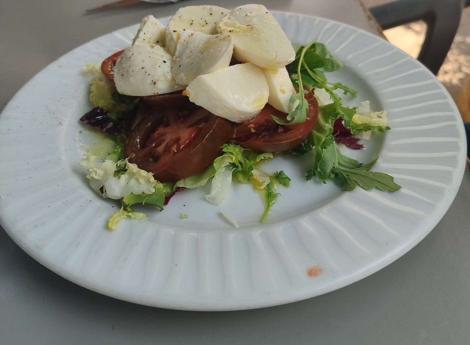 Ensalada de tomate y mozzarella fresca con brotes y aceite de oliva