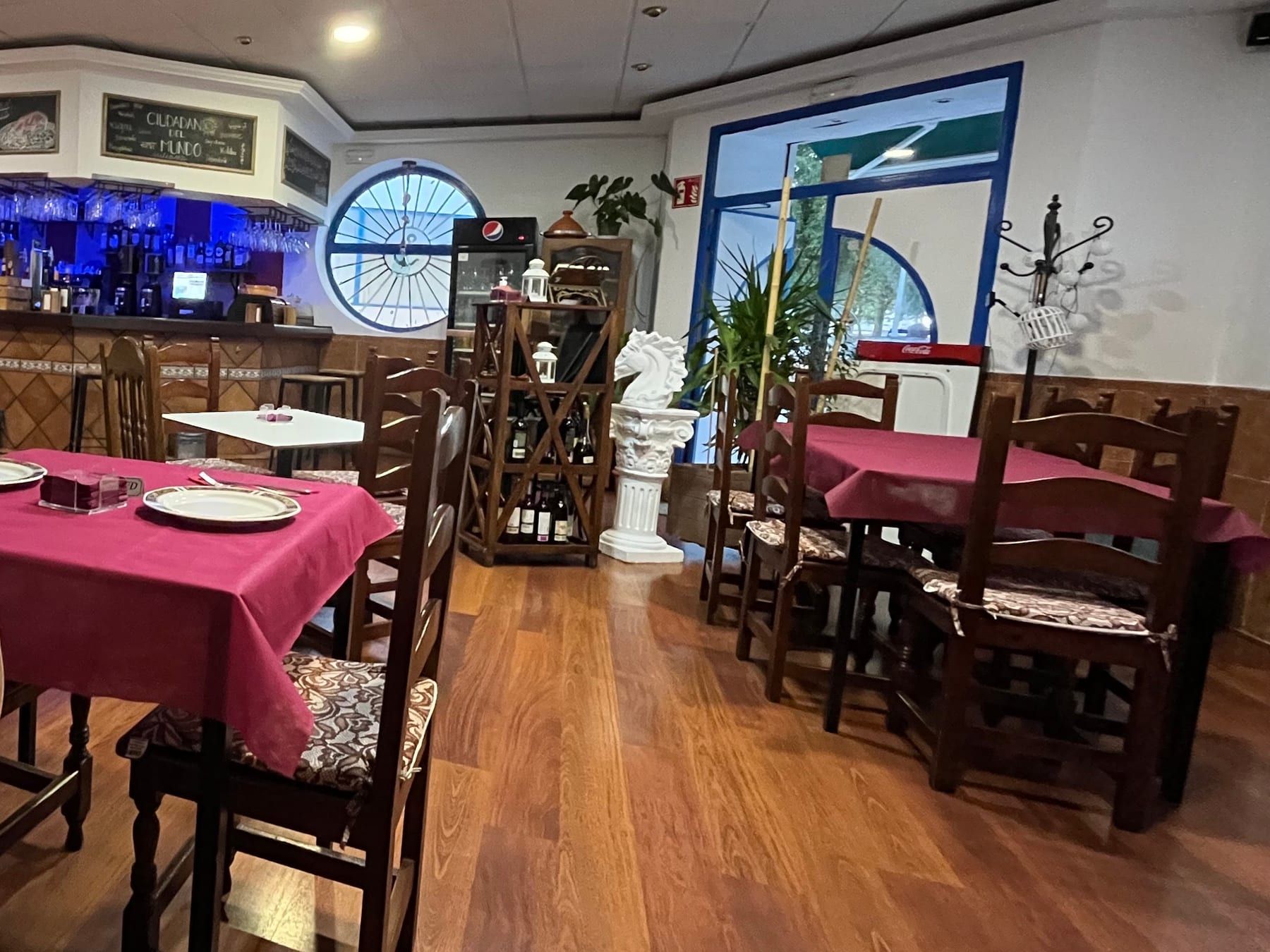Comedor del restaurante con las mesas puestas y la barra al fondo