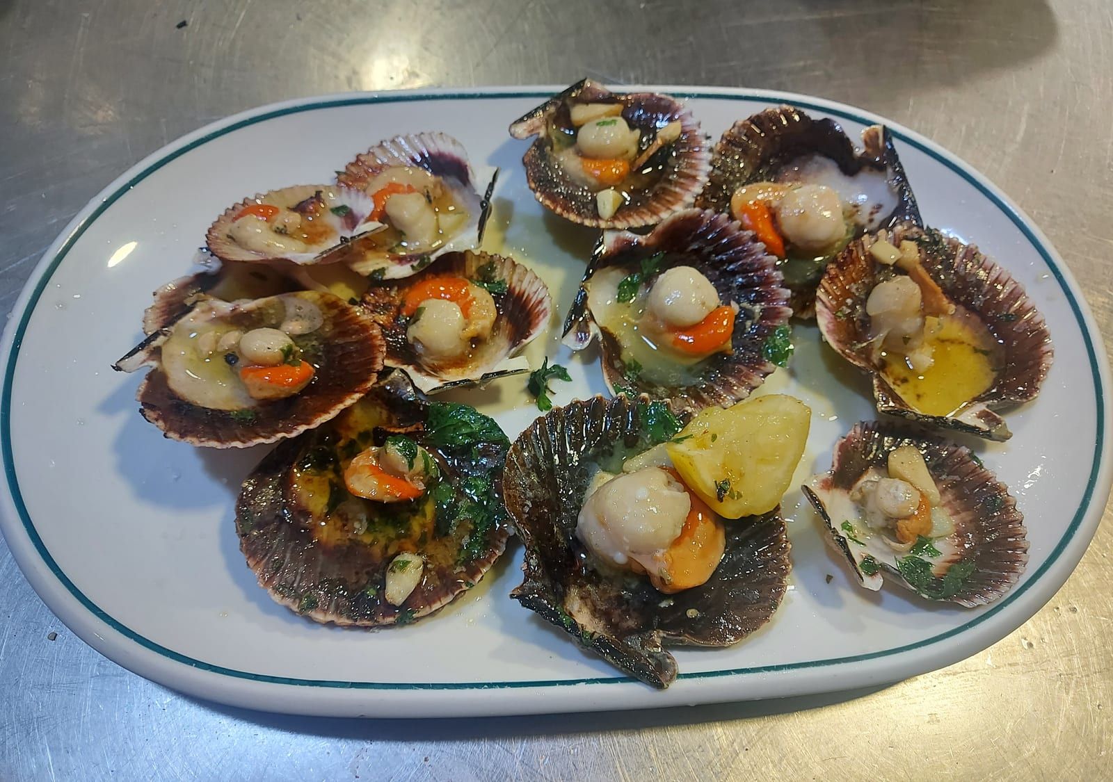 Zamburiñas a la plancha con ajo y perejil en fuente ovalada